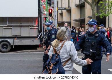 An Australian policeman confronting a woman at protest against vaccine mandates, restrictions, lockdowns at Martin Place, Sydney, New South Place, Australia on 20 Nov 2021.