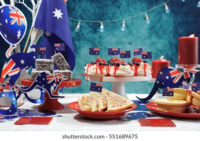Australian theme party table with flags and iconic food including mini pavlovas, lamingtons, meat pies and fairy bread.                          