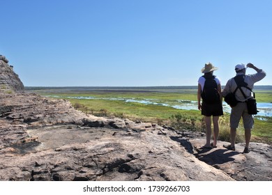 Australian Tourist Couple Hiking At Ubirr Rock Looking At The Dramatic Landscape View  Kakadu National Park In The Northern Territory Of Australia.