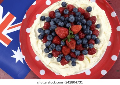 Australian Traditional Dessert, Pavlova, With Whipped Cream And Strawberries, Blueberries And Raspberries In Red White And Blue Theme With Australian Flag. Overhead.