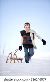 Austria, boy pulling sled in snow