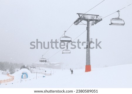 Austria winter ski resort - Mayrhofen in Tyrol. Austrian Central Alps. Ahorn mountain chairlift in snowfall skiing conditions.