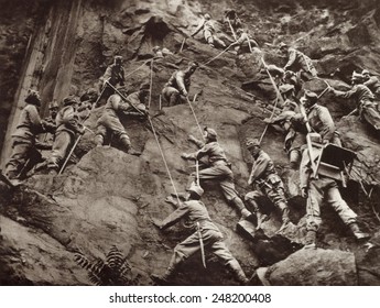 Austrian mountain troops in the Isonzo district, clinging to rocks and helping each other along by ropes. They are climbing over mountain pass to surprise an Italian detachment. 1915.