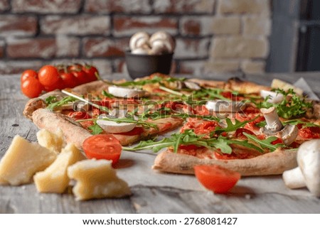 An authentic artisan pizza with a crispy thin crust presented on a rustic wooden table with a brick wall background. Topped with fresh arugula, mushrooms, and cherry tomatoes, this low-angle shot emphasizes the handcrafted texture and gourmet quality of the meal. Surrounded by parmesan cheese chunks and fresh ingredients, it evokes a warm, industrial-chic dining atmosphere ideal for pizzeria branding, high-end menus, and culinary marketing.