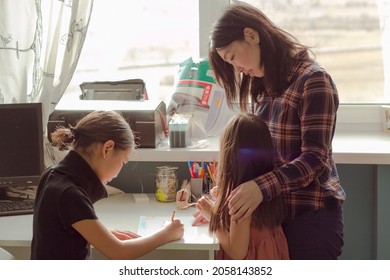 Authentic asian family mom   two daughters drawing in nursery   having fun together at home  happy family life   candid lifestyle in apartment