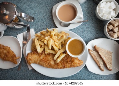 Authentic British Fish And Chips, With Curry Sauce, Buttered Bread And A Cup Of Tea