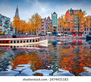 Authentic buildings of Amsterdam and trees covered with orange and crimson leaves reflected in the calm waters of famous Dutch channel. Stunning morning scene of Netherlands, Europe. - Powered by Shutterstock