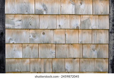 Authentic cedar shingle wall background evokes traditional wood house charm. Textured, natural, and weathered, ideal for rustic architecture.
