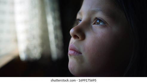 Authentic Close Up Shot Of Happy Little Girl Is Smiling While Looking Outside A Window Just Woke Up In A Morning In A Sunny Day. Concept: Life, Happiness, Family, Dreams, Hope, New Beginning,childhood