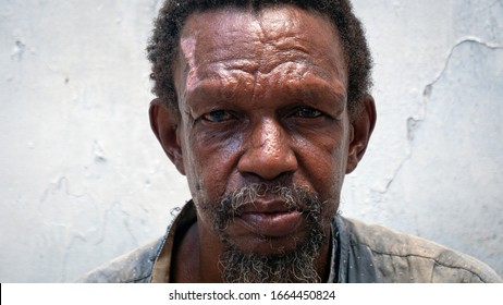 Authentic close up shot of middle aged african labour man is looking in camera on a background of an old building wall. Concept: life,charity,poverty, authenticity, father - Powered by Shutterstock