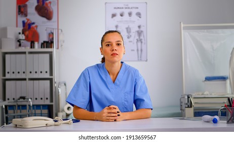 Authentic Experienced Woman Nurse Talking To Camera And Giving Online Medical Consultation From Private Modern Clinic. Remote Healthcare Service, Video Health Conference, Telemedicine, Virtual Meeting