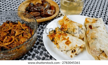 Authentic halal chicken wrap platter served with spicy curry bowl, sweet dates and herbal tea. Traditional Ramadan meal concept with rich Middle Eastern flavors and elegant presentation.