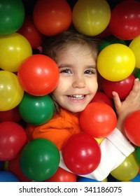 Authentic image of a toddler girl laughing in a ball pit