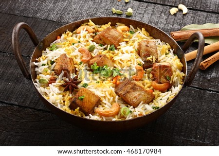 Authentic Indian cuisine-Fish biriyani or pilaf served in a cast iron cooking pot,,Selective focus photograph.