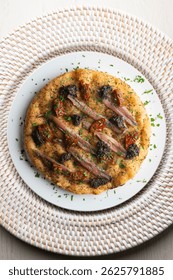 Authentic Italian focaccia with salted anchovies, sun-dried tomatoes, and black olives. Top view table with christmas decorations.