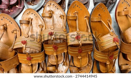Authentic Kolhapuri chappals displayed in vibrant rows, showcasing handcrafted Indian leather footwear with intricate detailing and traditional artisan craftsmanship at a local market.
