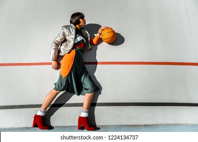 Authentic Lady. Abnormal Fashionable Woman Lying In Weird Pose With Ball In Her Hand