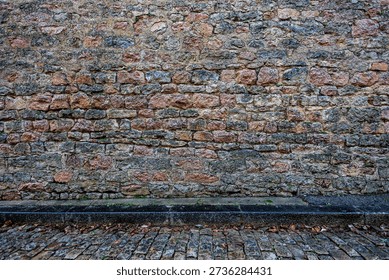 Authentic medieval stone wall texture from Semur-en-Auxois, France. Ancient limestone masonry with rough irregular blocks. Historical architectural background of a fortress or castle wall.