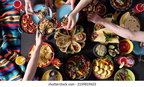 An authentic Mexican family celebrates Cinco de mayo together at a festive table. Mexican food. - Shutterstock ID 2159819653