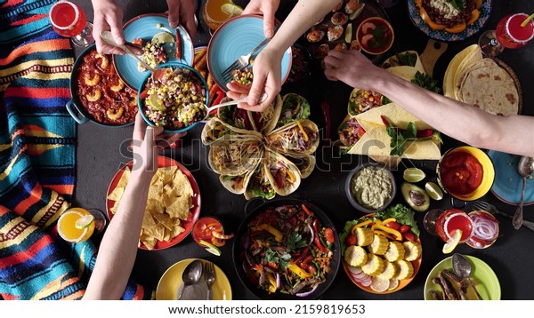 An authentic Mexican family\
celebrates Cinco de mayo together at a festive table. Mexican\
food.