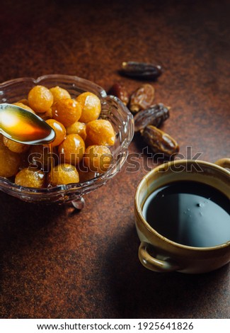 An authentic Middle Eastern dessert called Luqaimat or fried dumplings served with sweet date syrup. 
