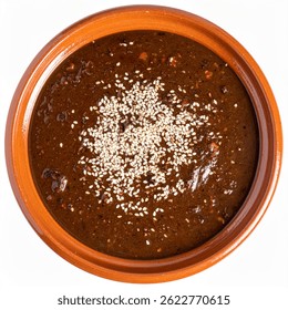 Аутентичная моль поблано с курицей, показывающая сложную текстуру соуса и семена кунжута в ручной глине казуэла изолированного фона