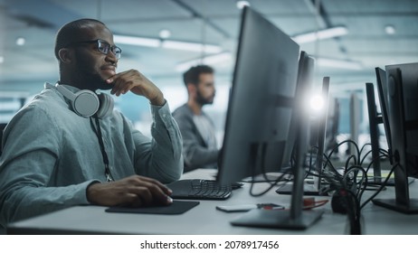 Authentic Office: Motivated Black IT Programmer Working On Desktop Computer. Male Website, Software Engineer Developing App, Program, Video Game. Terminal With Coding Language.