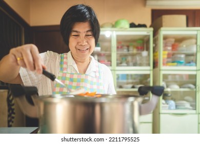 Authentic Portrait Asian Elderly Woman. Cooking With Love For Family Dinner Food Concept. Local Traditional Thai Style Indoors Kitchen At Home. Eye Looking At Camera.