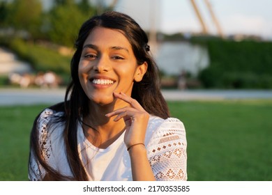 Authentic Portrait Of Beautiful Smiling Indian Woman Looking At Camera Sitting In Park, Copy Space. Natural Beauty Concept 