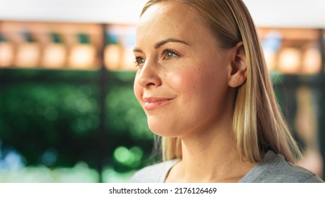 Authentic Portrait of Beautiful Young Female in Kitchen Room at Home Looking Thoughtfully at Her Backyard. Attractive Blond Woman Poses for Camera and Smiles. Happy Person with Healthy Lifestyle. - Powered by Shutterstock