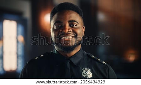 Authentic Portrait of Happy and Handsome Black Policeman in Universal Uniform Smiling at Camera. Successful African American Law Enforcement Agent. Courtroom Security Guard at Work.