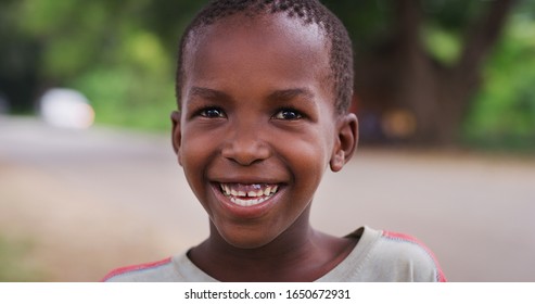 Authentic portrait of happy rural african  boy is smiling in camera on a village background. Concept: charity, people,life, happiness, authenticity - Shutterstock ID 1650672931