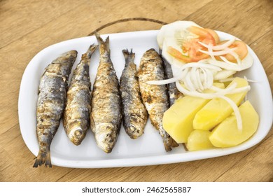 Authentic Portuguese cuisine: Grilled sardines with boiled potatoes and fresh salad, served in a traditional restaurant. - Powered by Shutterstock