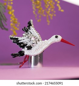 Authentic Representation Of Handmade Craft Beaded Stork Bird As Accessory Brooch Pin Isolated Overt Pink Background With Mimosa Flowers On Top