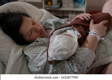 Authentic Representation Of Young Mother Holding Her Baby After Giving Birth At The Hospital