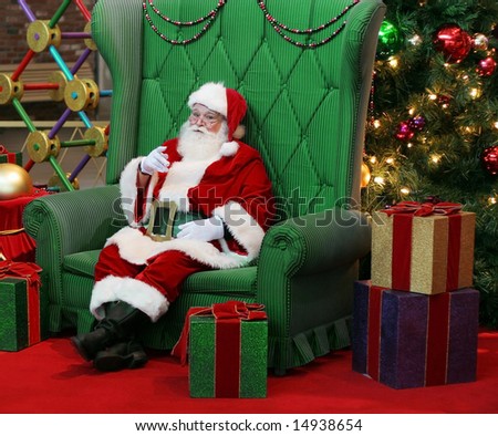 authentic santa claus sitting in large green chair surrounded by presents and decorations - Christmas Decorations Large Santa Claus authentic santa claus sitting in large green chair surrounded by presents and decorations - Christmas Decorations Large Santa Claus