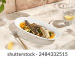 Authentic Seabass Fillet with Vegetables and Carrot Sauce in Sunlit Still Life.