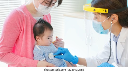 authentic shot of asian mother and infant in pediatrics clinic - doctor examine baby health by stethoscope
