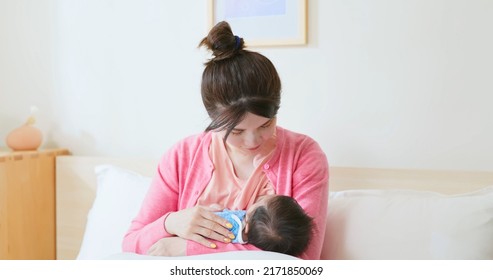 Authentic Shot Of Asian Mother Sitting On Bed Is Breastfeeding Her Baby