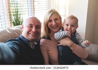 Authentic Shot Of Happy Family Mother Father Son Taking Selfie Together And Having Fun On The Sofa At Home - Lifestyle And Family Concepts With Also Parenthood, Childhood And Quality Time