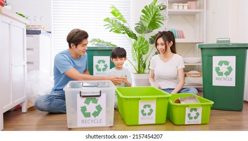 Authentic shot of real asian parents are teaching kid how to recycle help the boy aware environmental importance - they sit in living room and sort garbage into different bins - Powered by Shutterstock