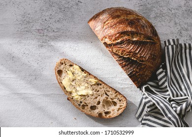 Authentic sourdough bread. Leavened bread. Sourdough starter. Whole wheat bread. Homemade. Piece of bread. Salted butter. Rustic organic bio product. Handcrafted product. Grey white backdrop. Slice - Powered by Shutterstock