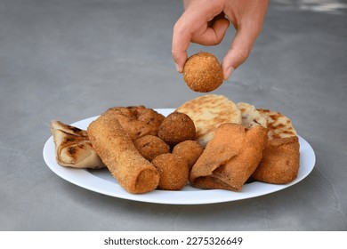 Authentic Sri Lankan different street food, short eats. Vegetable roti, coconut roti, cutlets, mutton rolls take from plate. Snacks made with tuna, potatoes, onion and deep fried. Close up