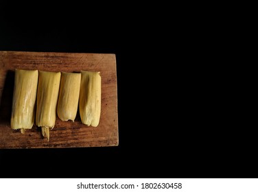 Authentic Tamale with corn leaf on wooden board with black background, typical food of Guatemala