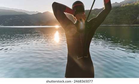 Authentic triathlon athlete getting ready for swimming training on lake - Powered by Shutterstock