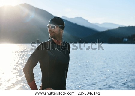 Authentic triathlon athlete getting ready for swimming training on lake