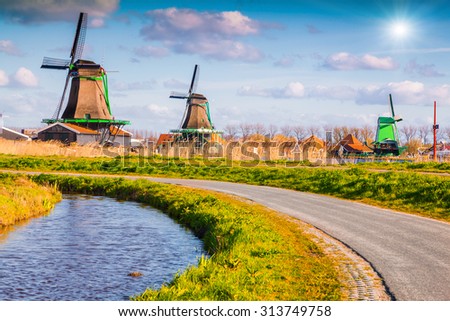 Authentic Zaandam mills on the water channel in Zaanstad village. Zaanse Schans Windmills and famous Netherlands canals, Europe