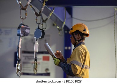 Authorise Auditor Personal Wearing Side Impact Safety Helmet Standing Inspecting An Inertial Reel Fall Arrest, Fall Restraint Equipment At Training Centre Attached With Structure Beam Prior Used 