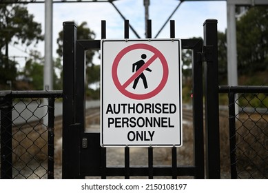 Authorised personnel only sign on a black metallic gate, with black fencing either site