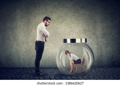 Authoritarian Angry Boss Businessman Looking At A Glass Jar With Captured Woman Inside 